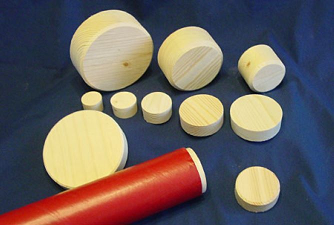 wooden bungs of various size sit next to a paper roll plugged with a wooden bung