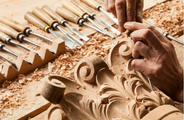 hands carving the top of a Corinthian column 